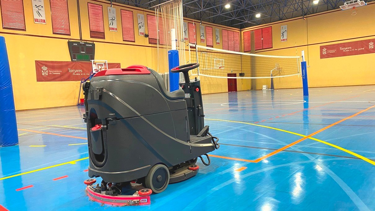Máquina fregadora en pista de voleibol bajo techo.